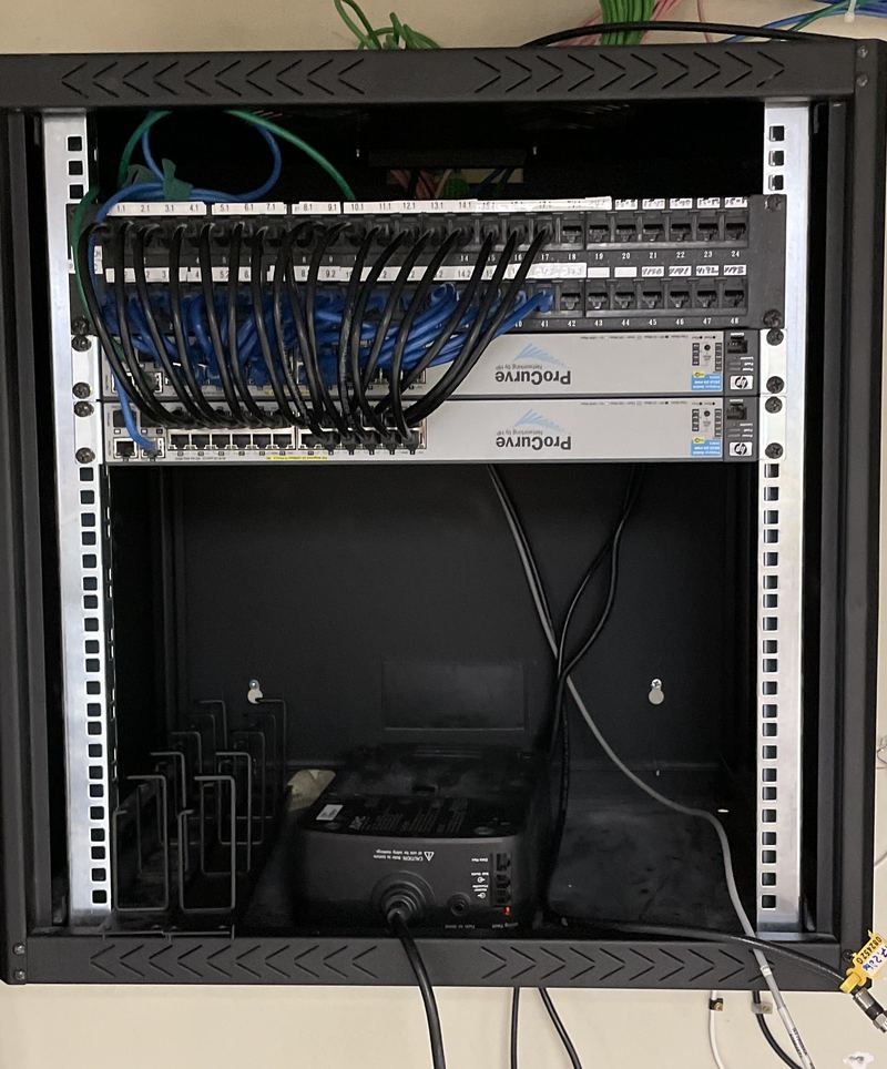 Network switches and patch panel in a wall-mounted rack serviced by Cape Cod Computer Repair